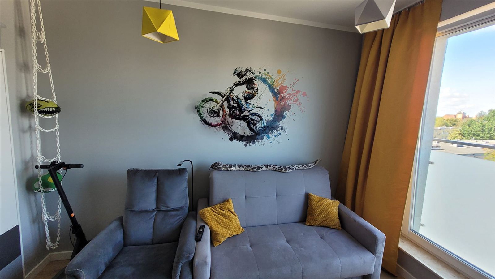 Salon z kolorową grafiką motocyklisty nad kanapą
