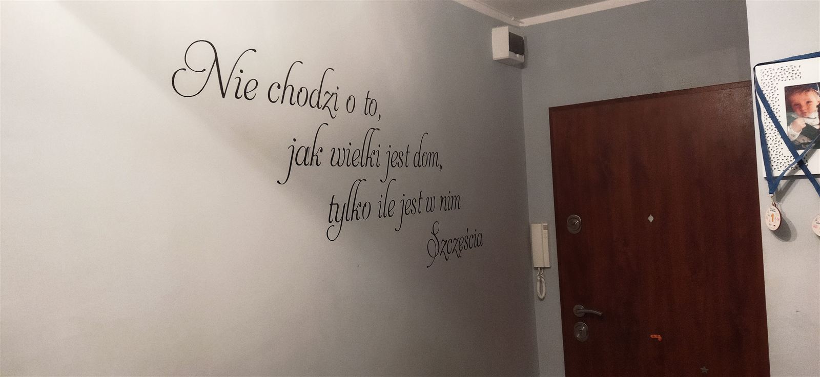 Cytat zapisany pisanymi literami na ścianie przedpokoju